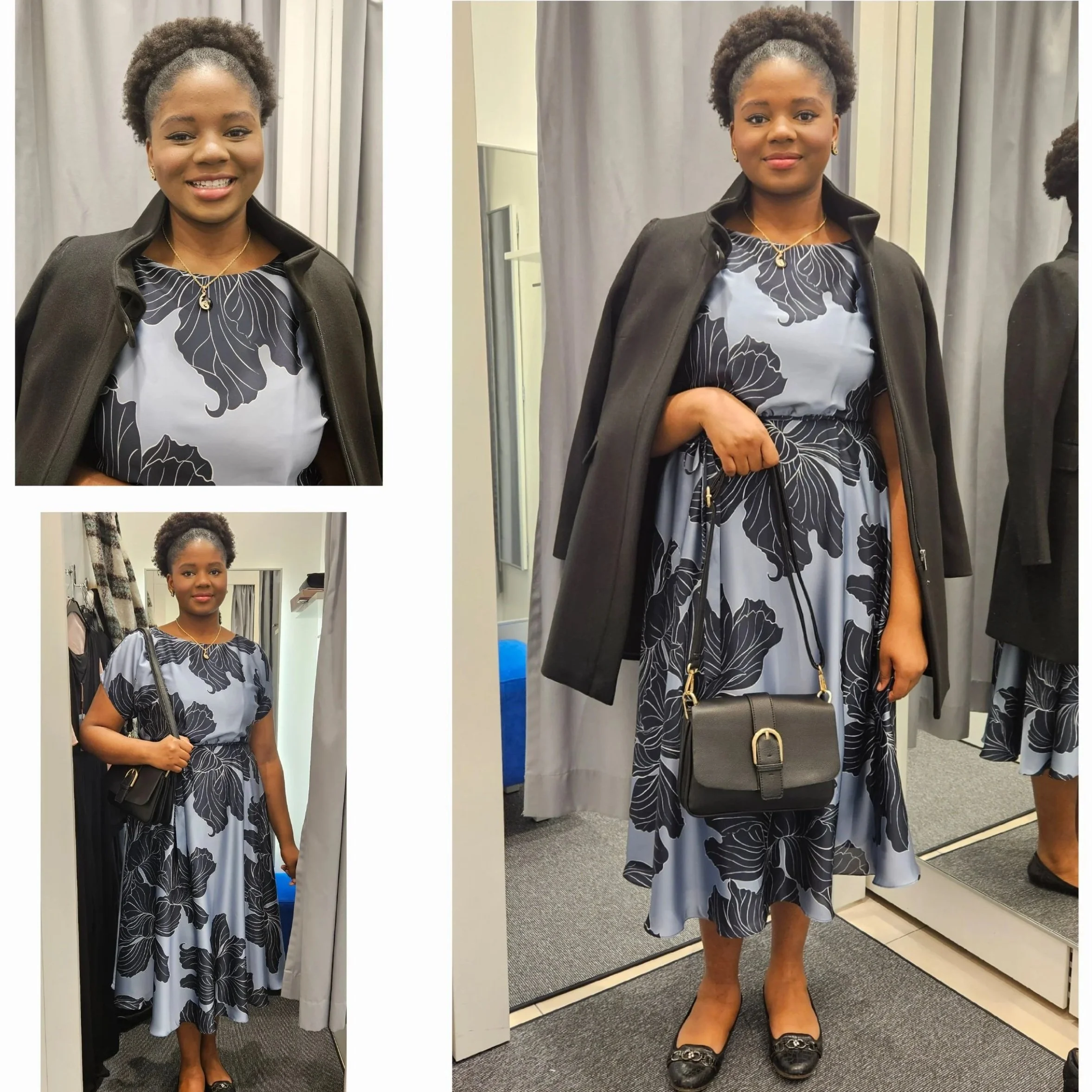 A woman with dark skin and curly hair pulled back, wearing a black coat over a gray dress with black floral pattern, gold jewelry, and holding a black handbag, standing in front of a gray curtain.
