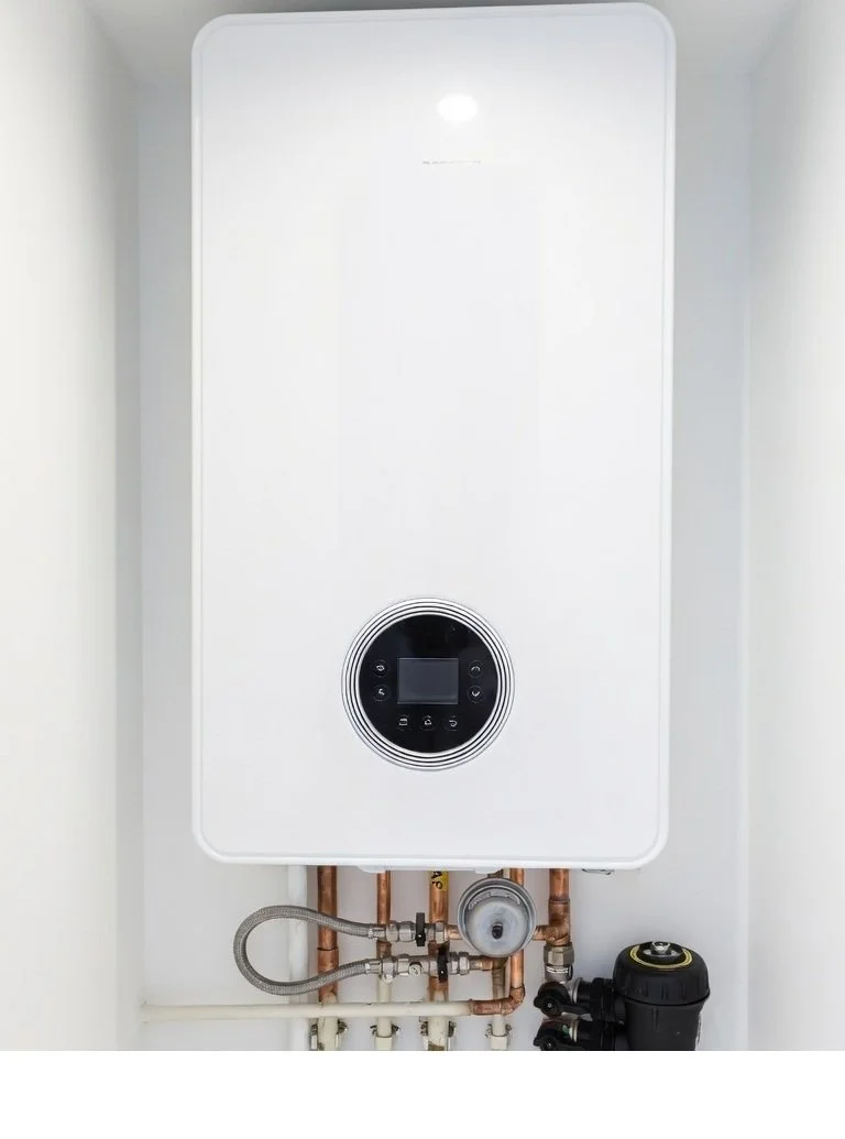 Modern tankless water heater with digital display and plumbing pipes underneath.