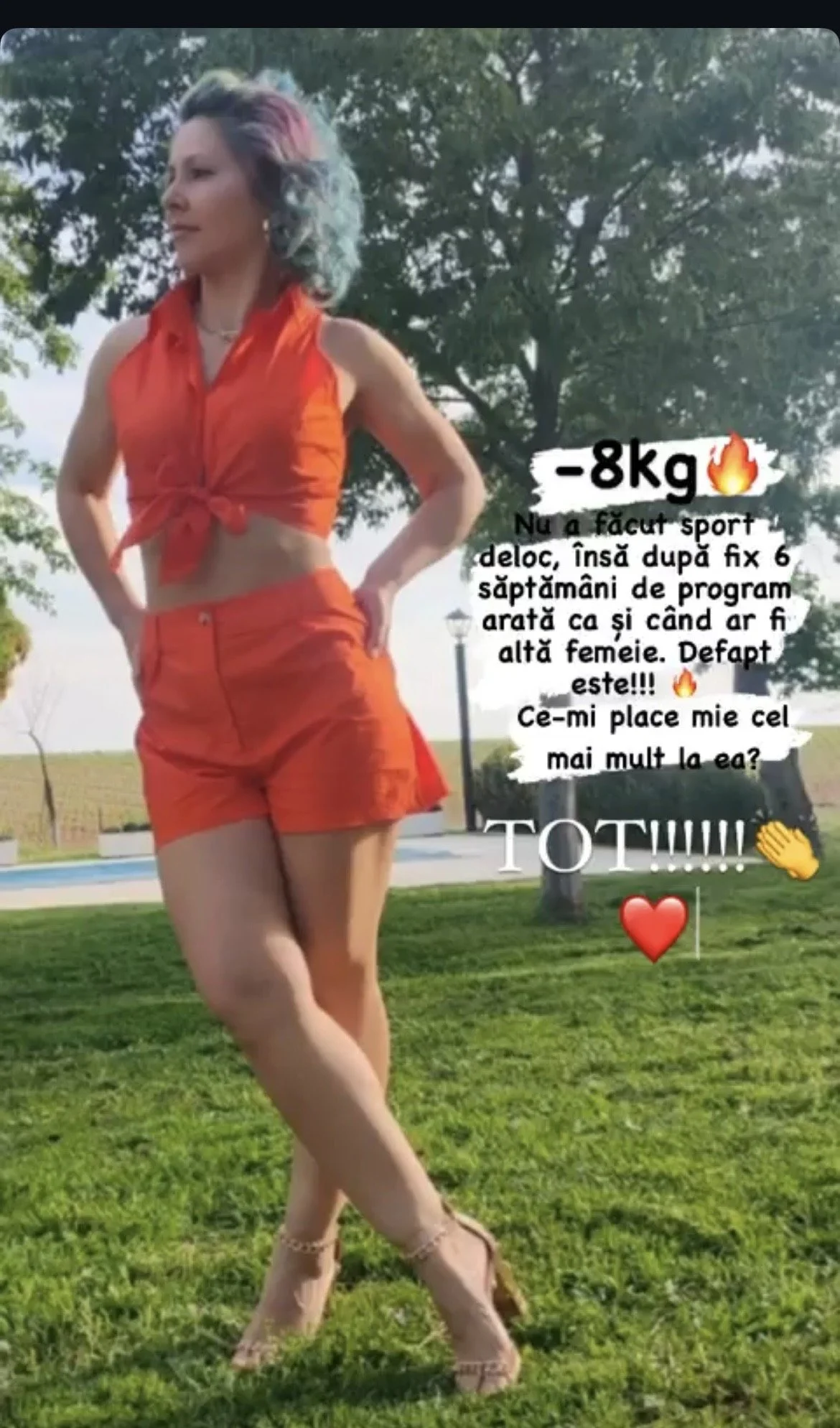 A woman with colorful hair standing outdoors on grass with trees and a swimming pool in the background. She is wearing a sleeveless orange top and matching orange shorts, and high heels. There is text and emojis overlaying the image.