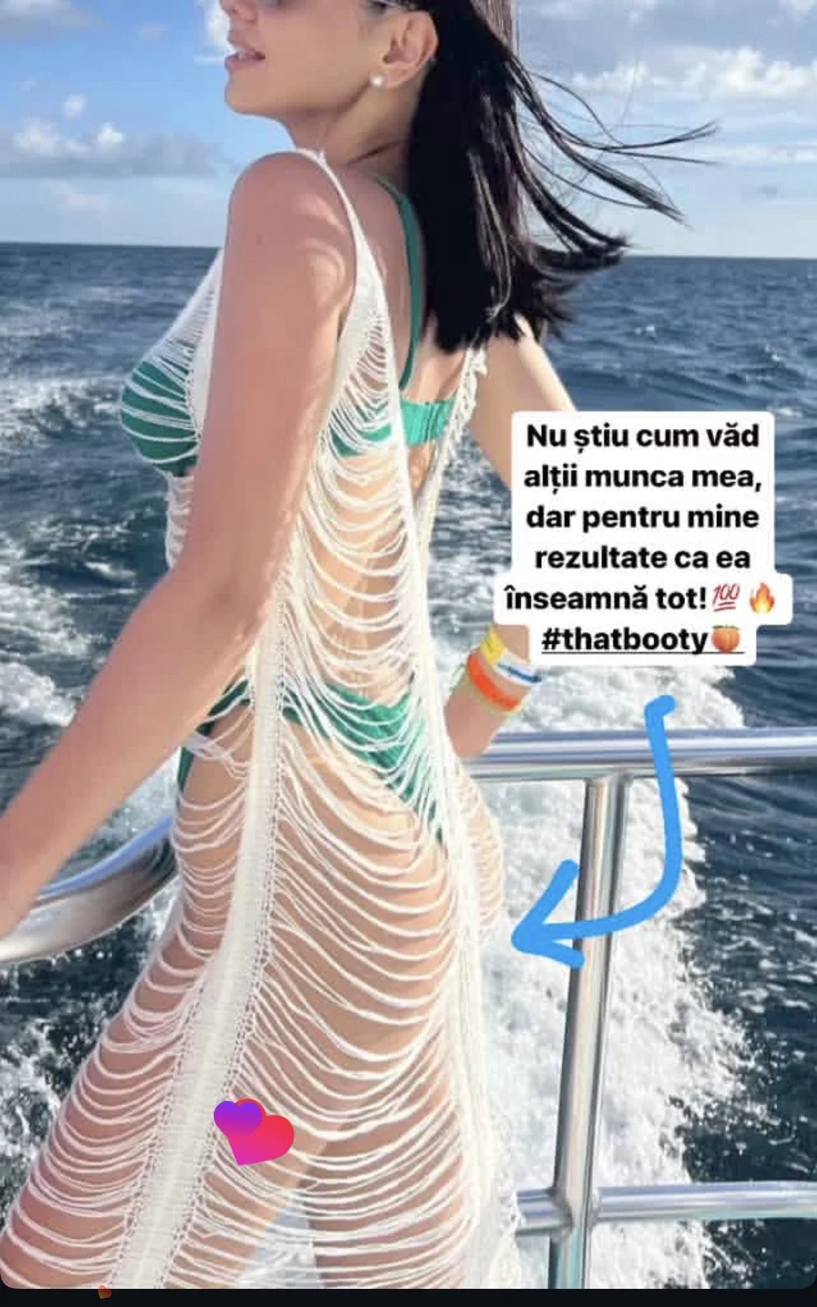 Woman in a revealing, ripped cover-up dress standing on a boat, with ocean and sky in the background.