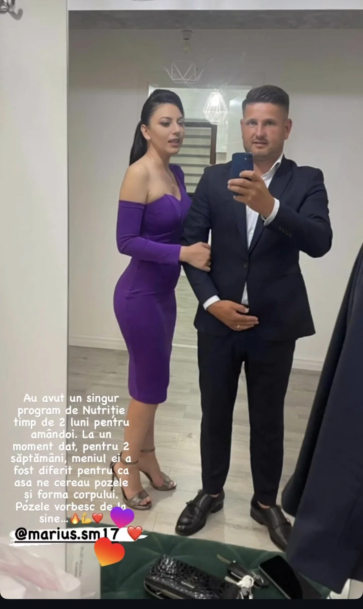 A man and woman taking a mirror selfie at an indoor venue. The woman is wearing a purple, off-the-shoulder dress and heels, while the man is dressed in a black suit and shoes. There is text in Romanian at the bottom left of the image, and a green sur
