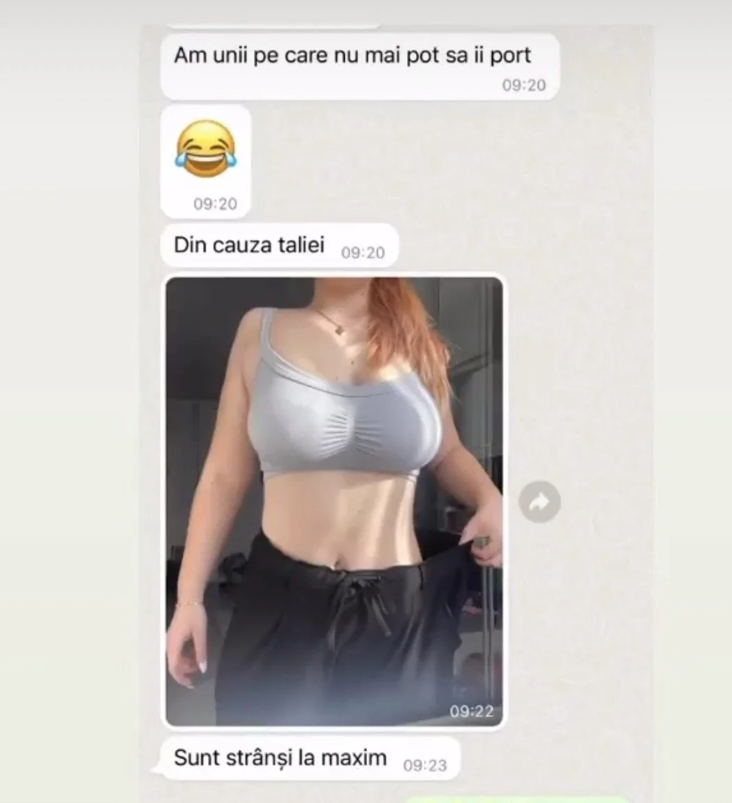 Screenshot of a messaging app conversation in Romanian, showing a woman in a gray sports bra and black sweatpants, standing indoors and holding her waistband, revealing her toned abdomen.