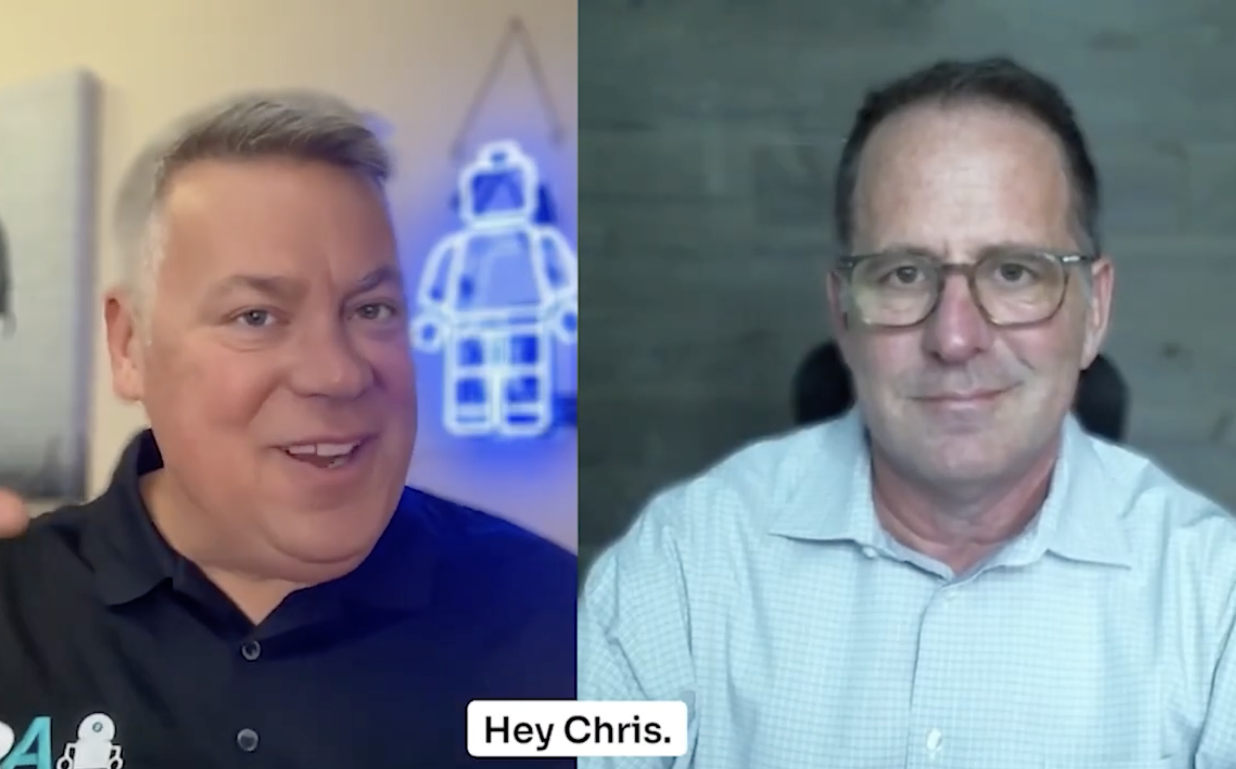 Two men in a split-screen video call. The man on the left has short gray hair, is smiling, and is wearing a black shirt. The man on the right has short dark hair, is wearing glasses, and a light blue checked shirt. The text overlay reads "Hey Chris."