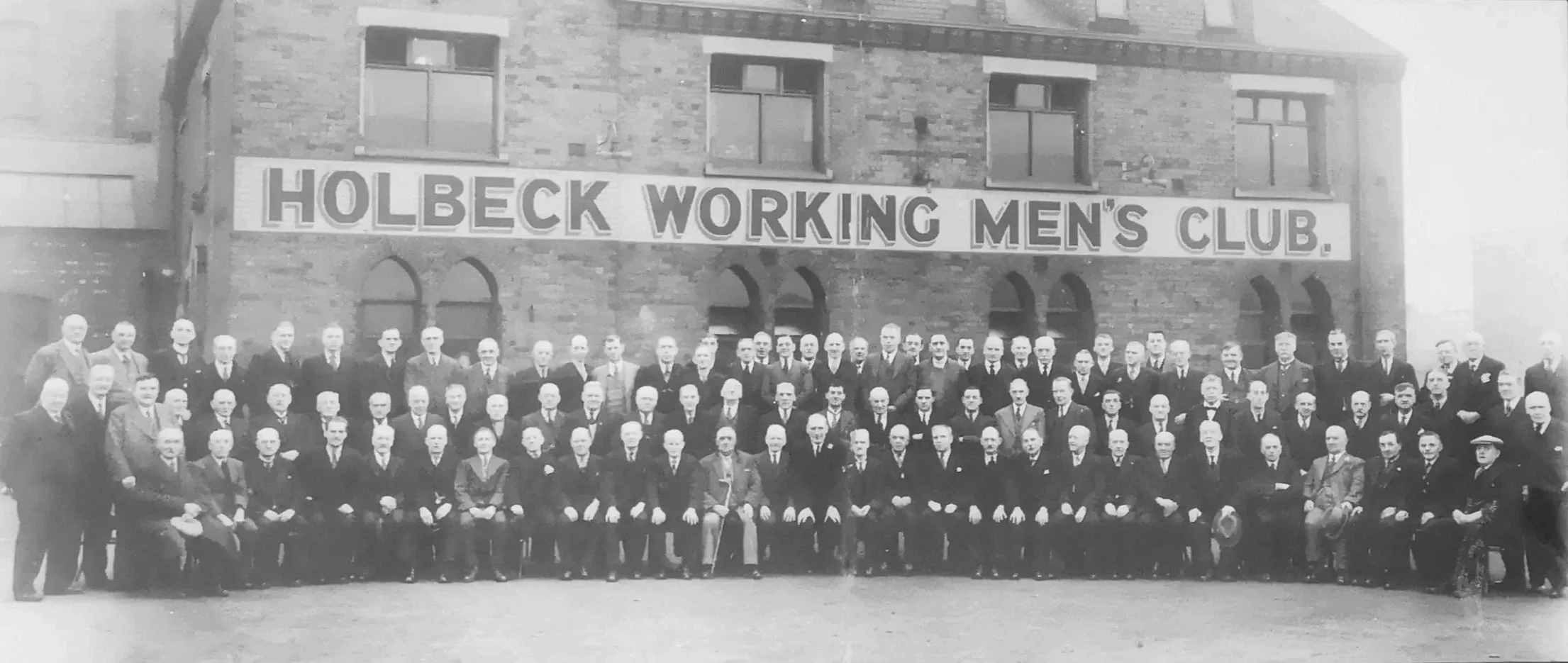 The Victorian members of the Holbeck Working Men's Club sat outside the buidling for a formal group photograph