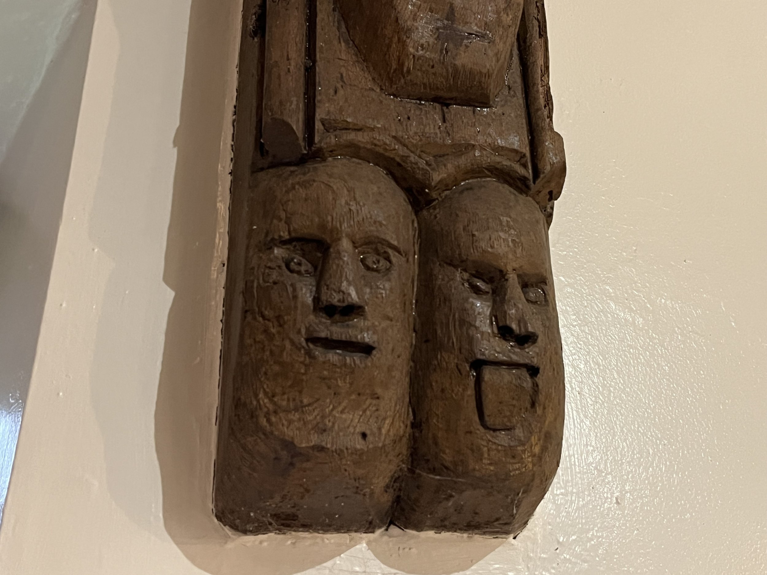 Comical pendant bosses of two men, one with his tingue out