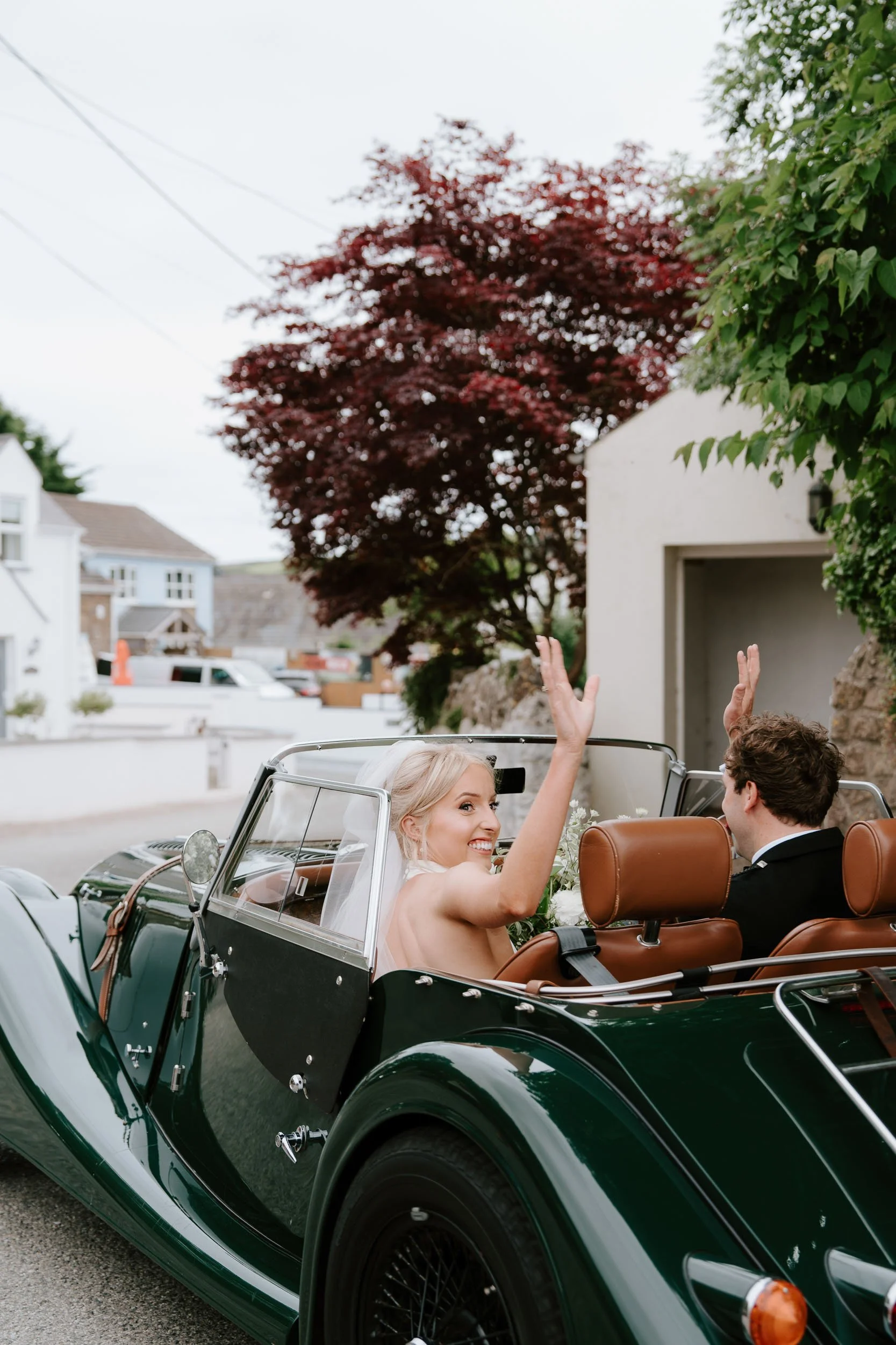Bride and groom leaving in vintage car just married celebration