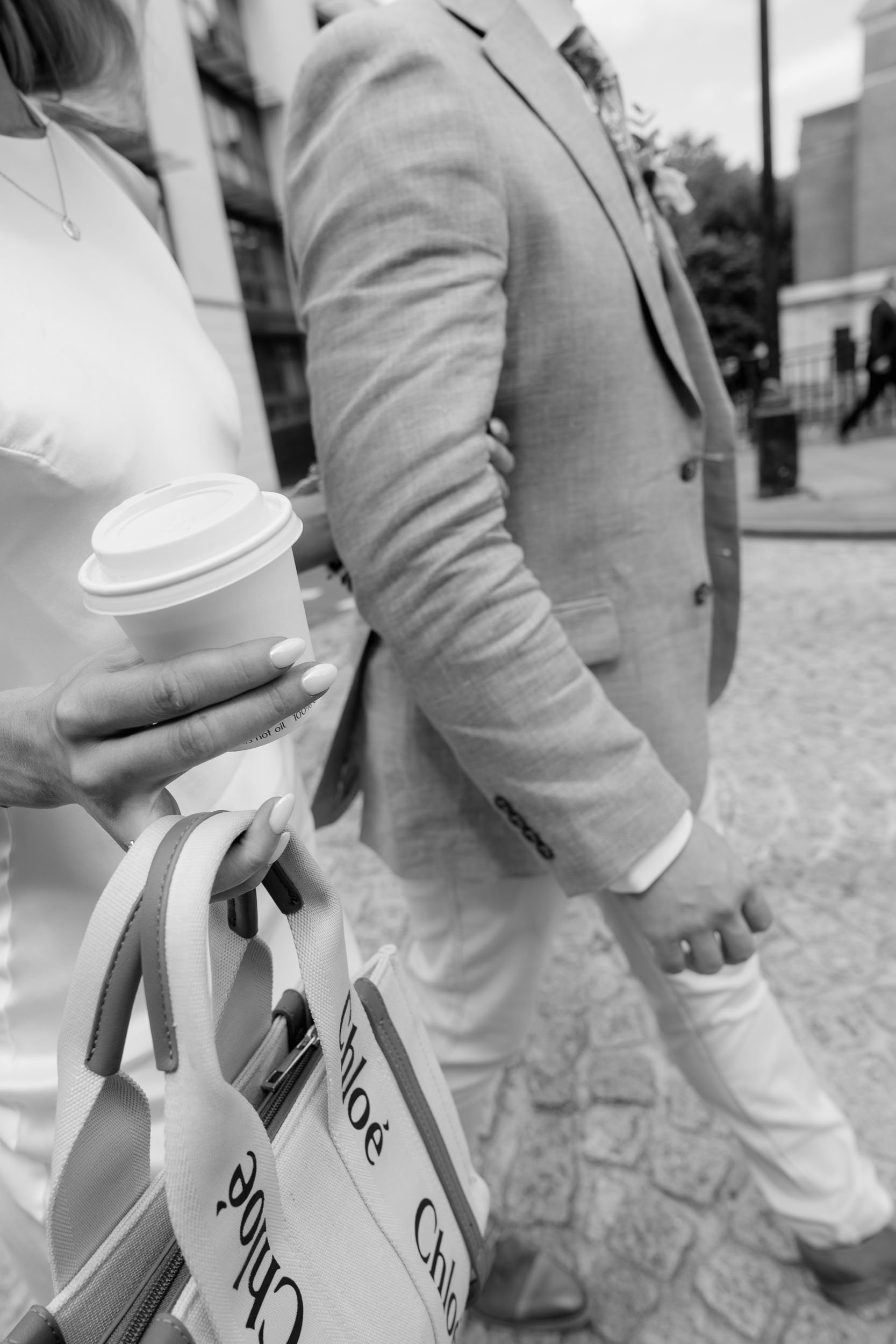 Couple holding hands with coffee candid wedding moment UK