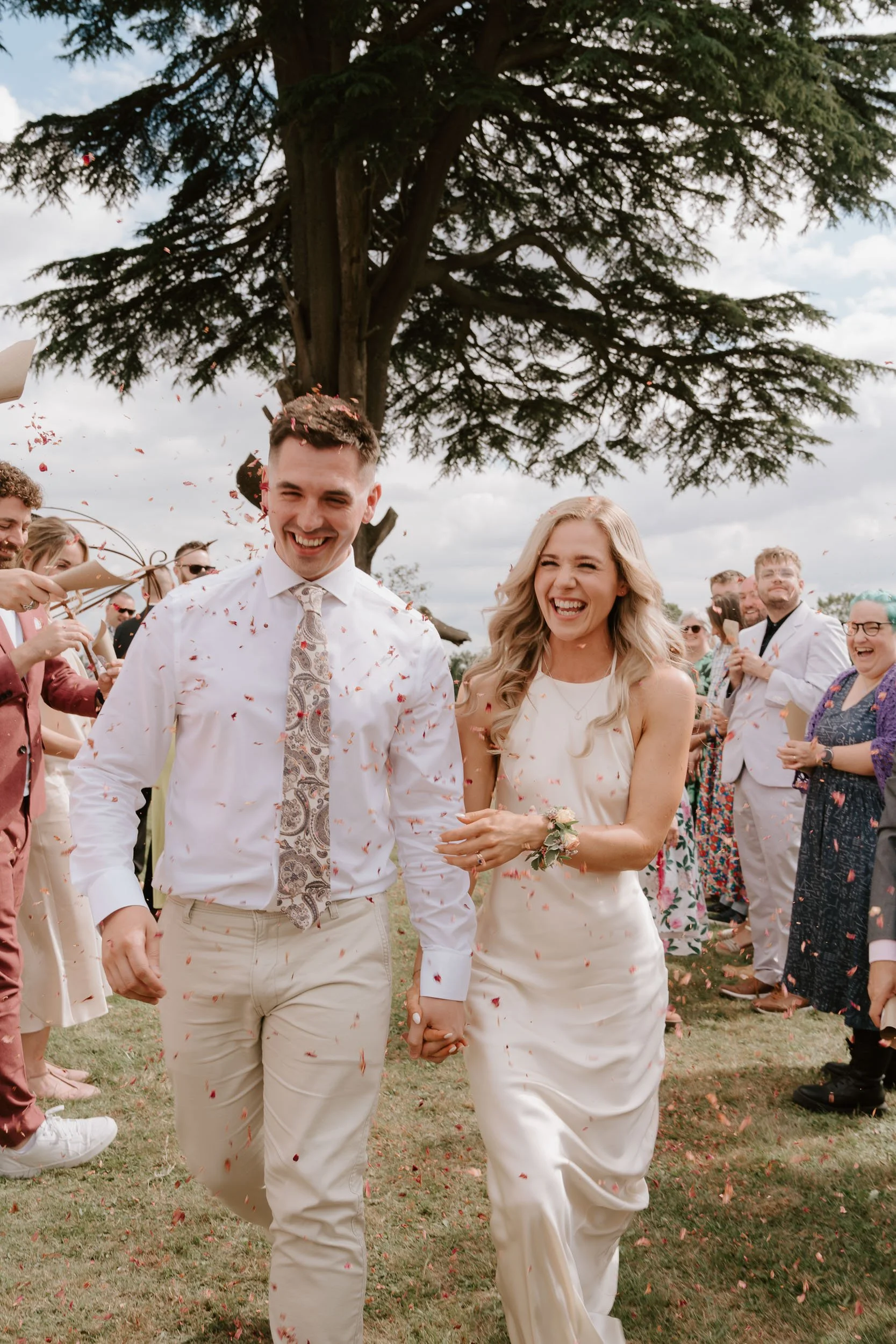 Confetti exit wedding candid couple walking guests celebration