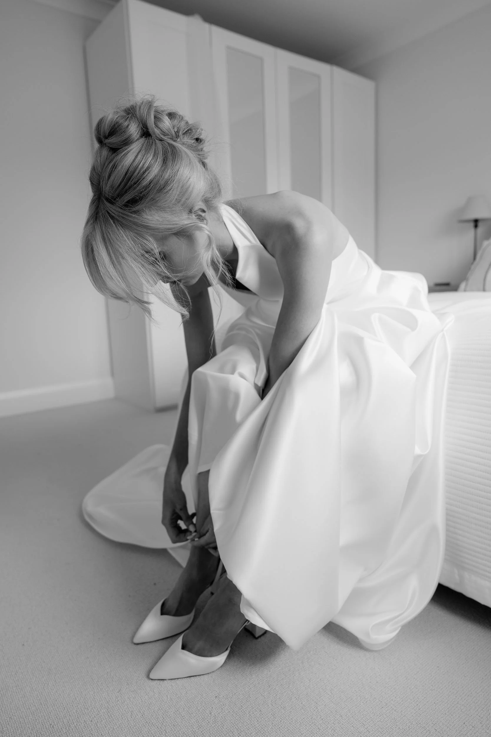 Bride getting ready candid moment adjusting wedding dress