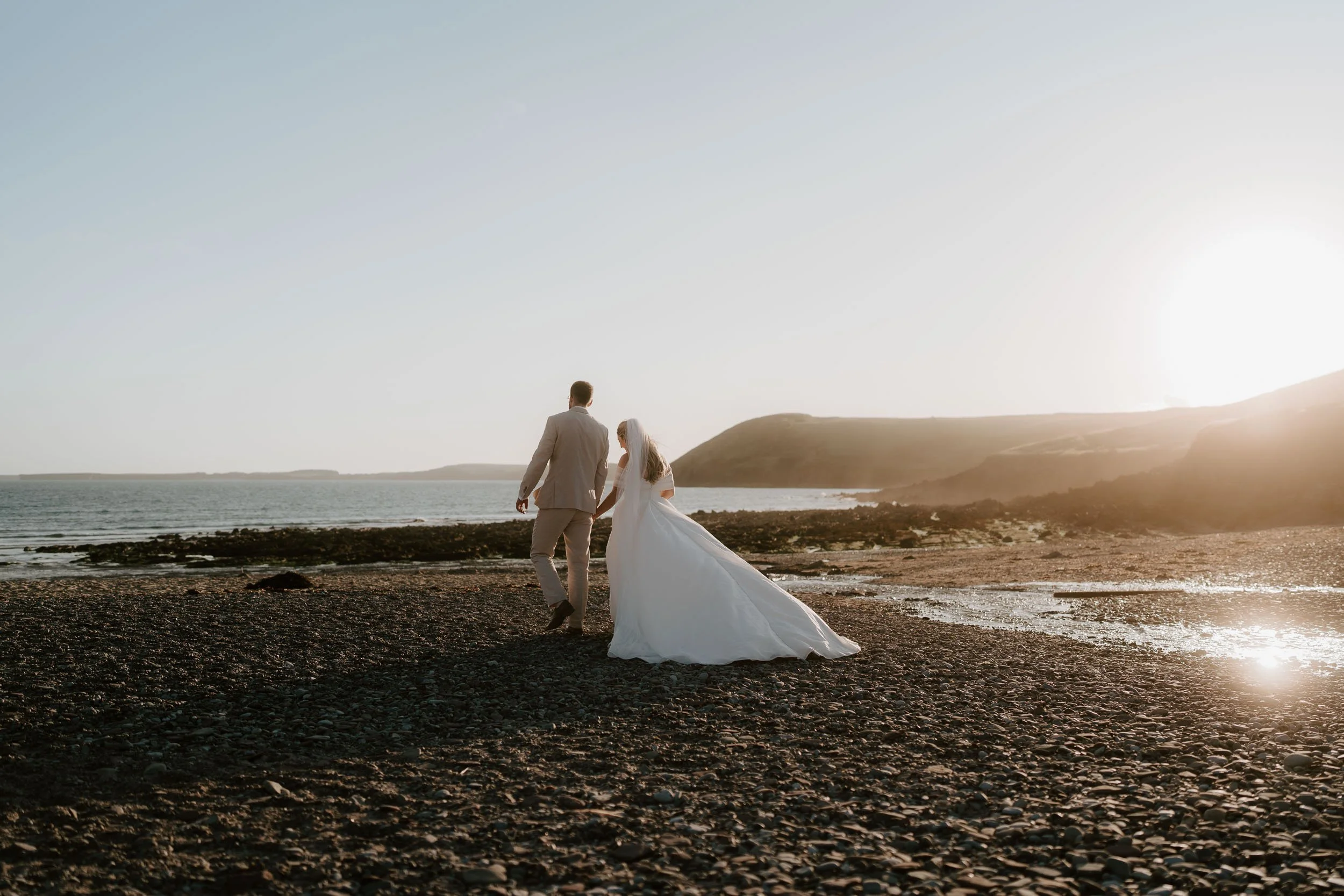 Bride and groom on Pembrokeshire coast during golden hour wedding portrait
