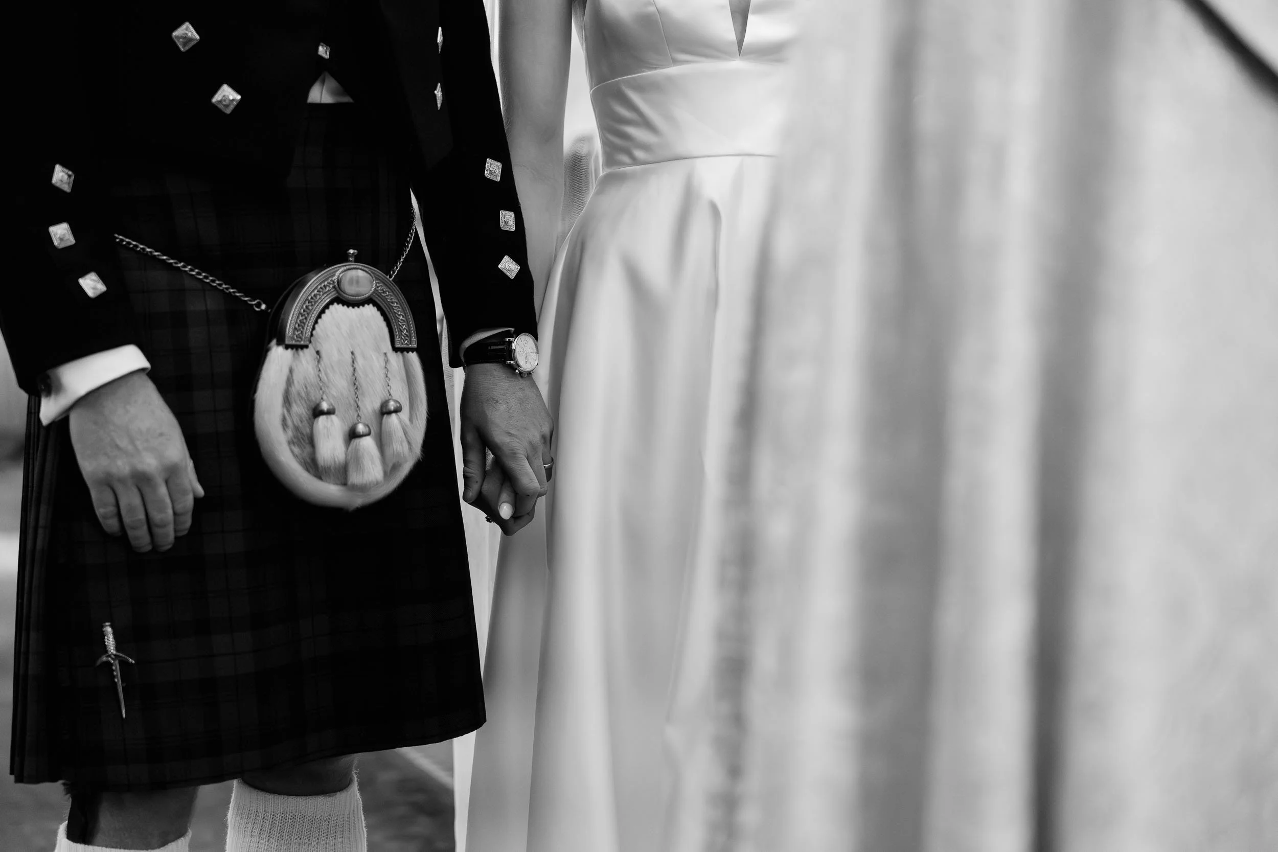 Bride and groom holding hands traditional attire black and white