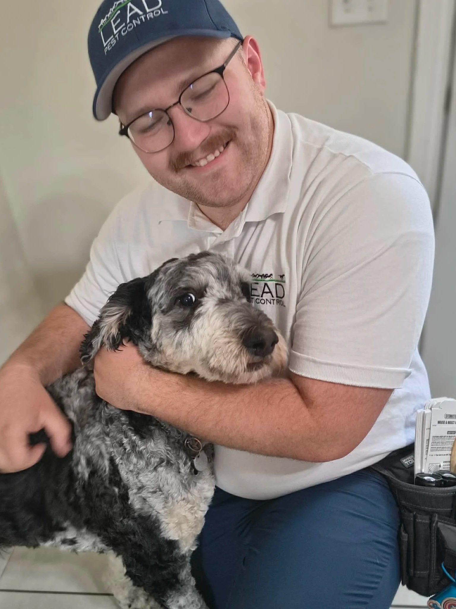 Pet-friendly pest control service in Elizabethtown KY with technician handling customer’s dog