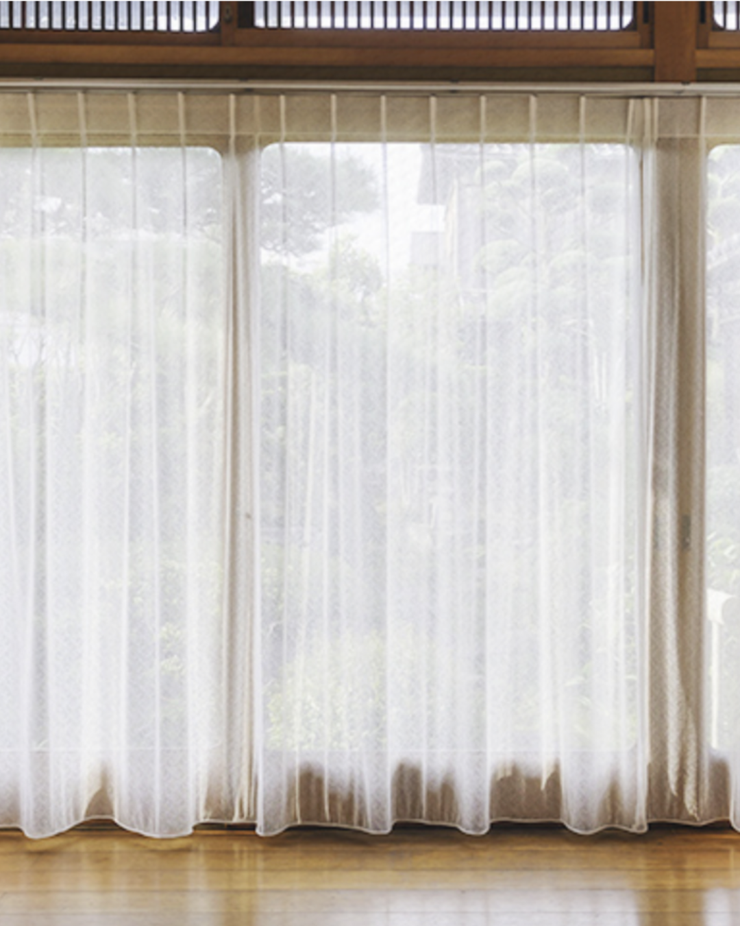 Vetro con tende trasparenti che lasciano passare la luce naturale da una finestra