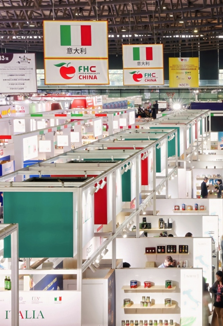 Stand con bandiere e simboli dell'Italia e di FHC China in una fiera internazionale.
