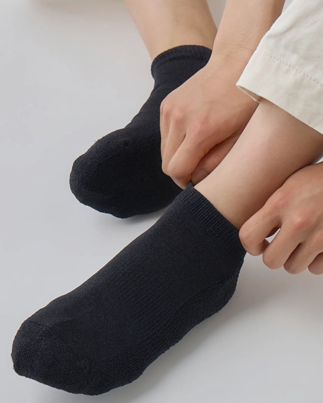 Una persona si sta togliendo una calza nera da una gamba.