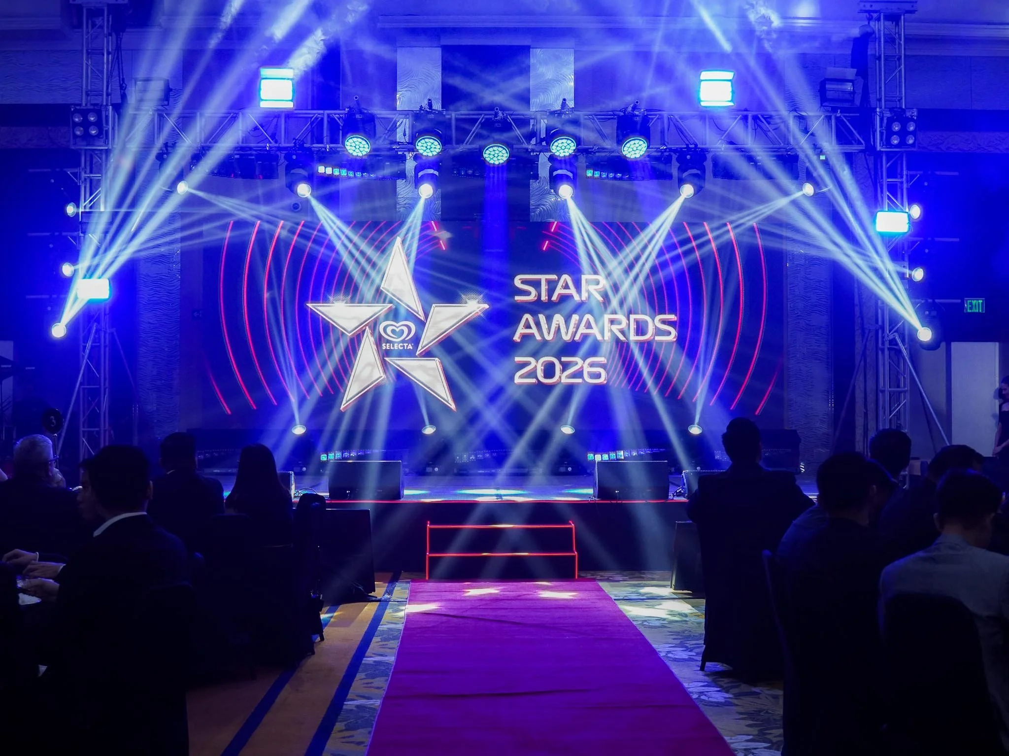 Stage setup with bright blue and white lights at the 2026 Star Awards event, with an audience seated in the auditorium.