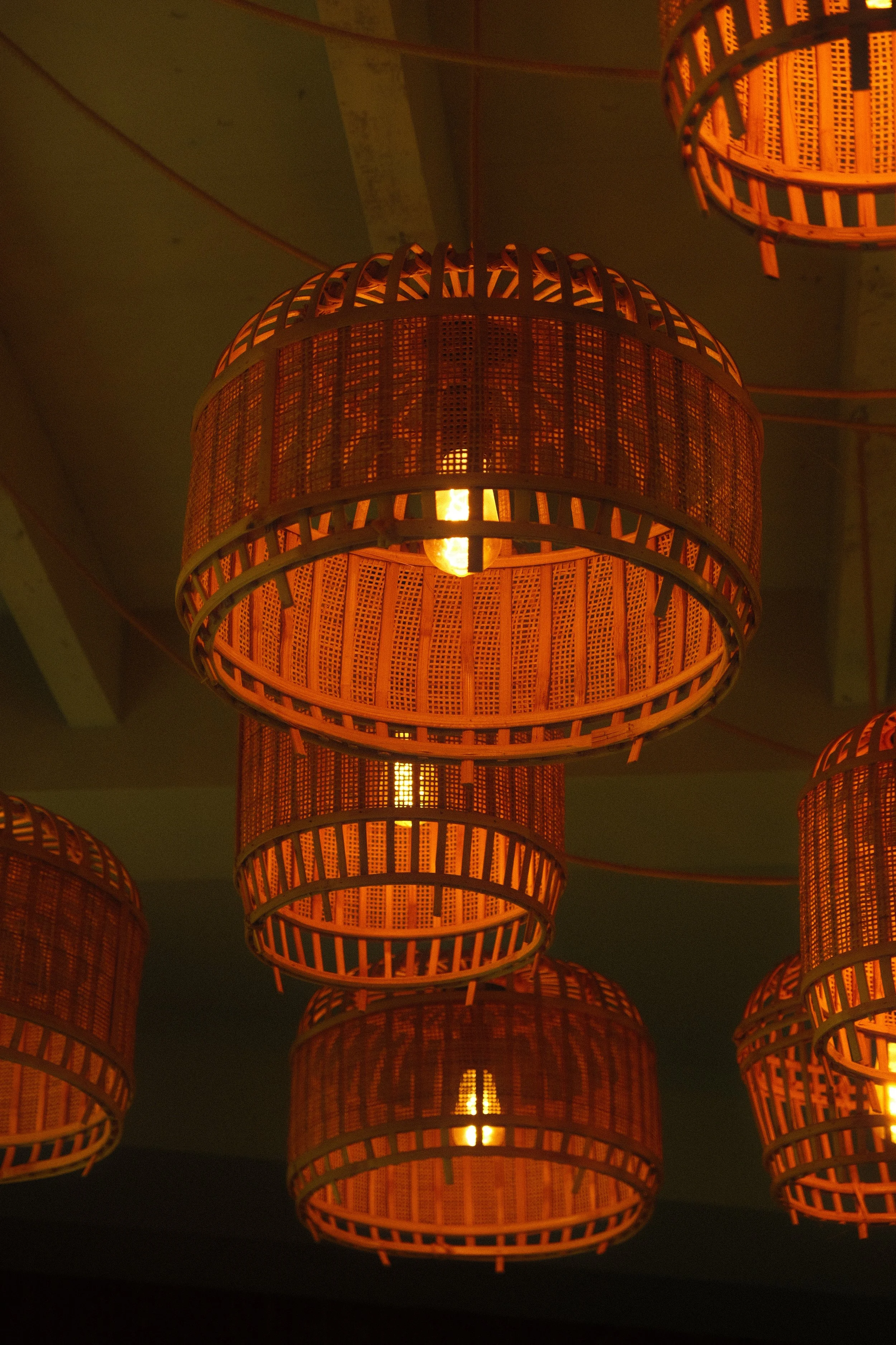 Multiple orange woven pendant lights hanging from the ceiling, emitting a warm glow.