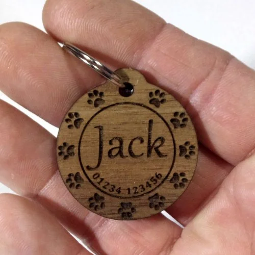 Wooden dog tag engraved with the name Jack, paw prints, and phone number 01234 123456.