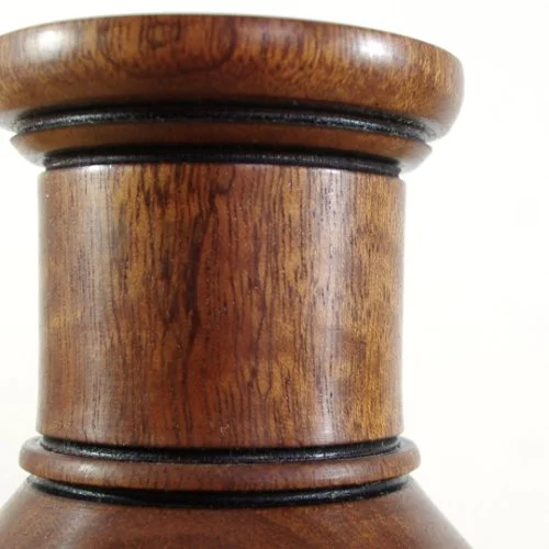 Close-up of a wooden vase, showing the top and middle sections with decorative black rings.