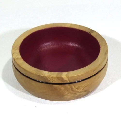 Wooden bowl with a red interior.
