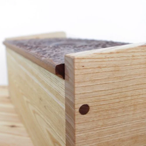 Close-up of a wooden box with a Walnut top, showing corner joint detail.