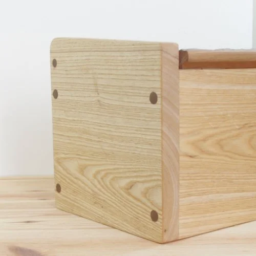 Close-up of a wooden box with visible dowels on the side.