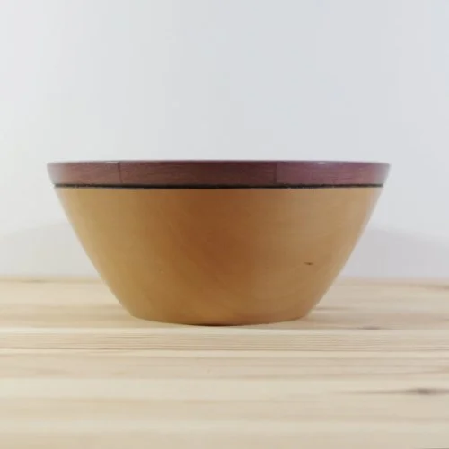 A steamed pear wooden bowl with a brown rim, placed on a light wooden surface.