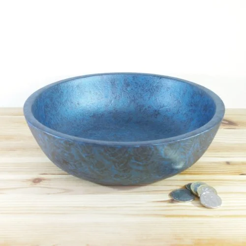 Blue wooden bowl on a wooden surface with some coins beside it.