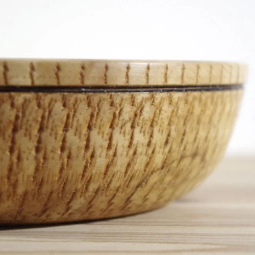 Close-up of a wooden bowl on a light-colored surface.