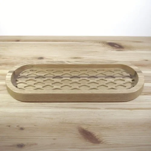 A wooden tray with a diamond honeycomb pattern inside, placed on a wooden surface.