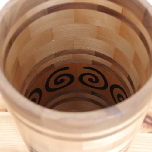 The inside of a wooden vase with black epoxy spiral patterns on the inside.