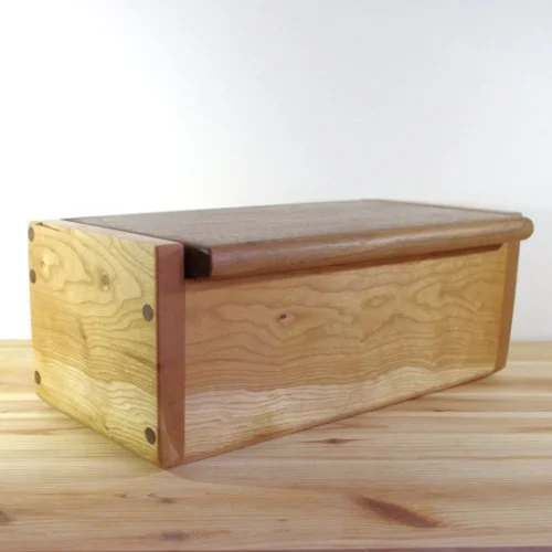 Ash Wooden box with a hinged lid on a light wood surface