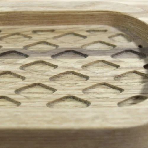 Close-up of a wooden object with diamond-shaped cutouts.
