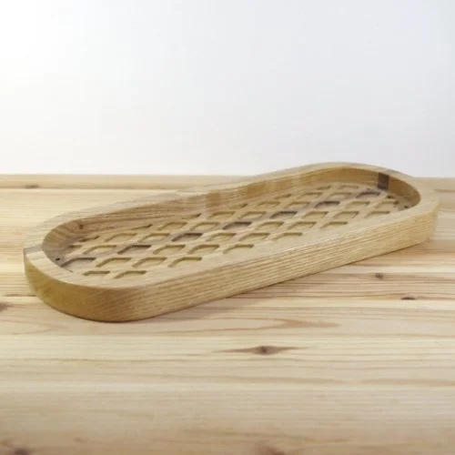 Wooden tray with a lattice bottom sitting on a wooden surface.