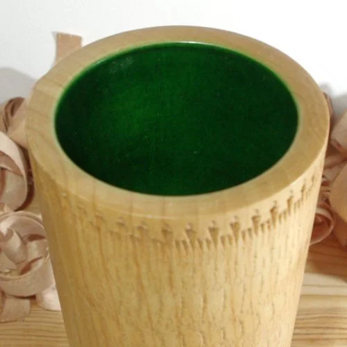 A wooden vase with a green interior.