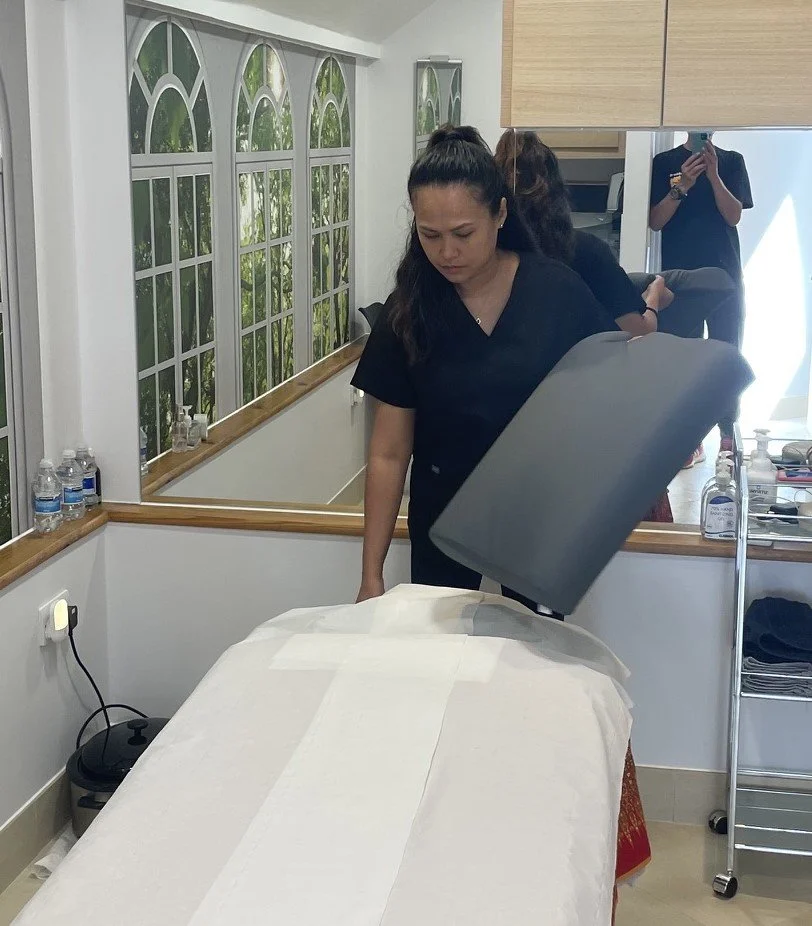 Massage therapist preparing clinic massage room