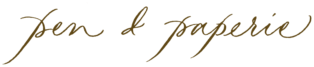 Text in gold cursive font that says 'pen & paperie'.