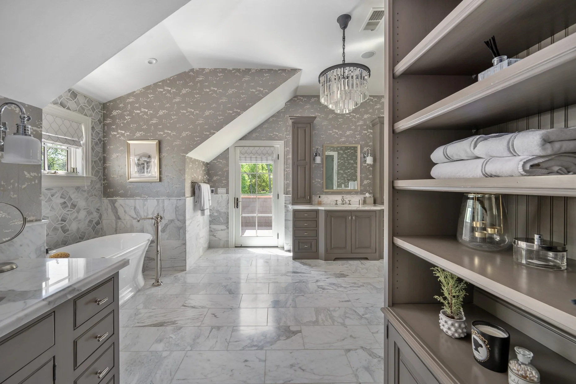 Exceptional bathroom with marble floors to vanity areas, stand alone tub and dormered angled ceilings