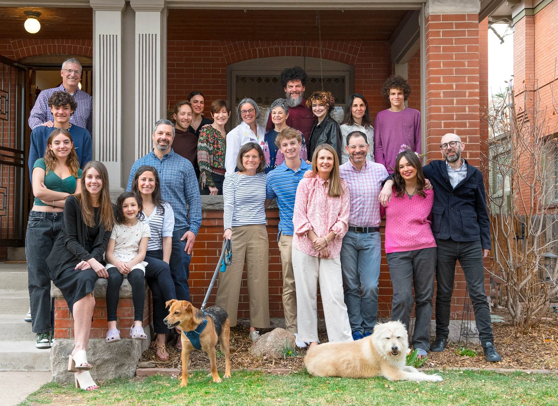 Family in front of home with 2 dogs
