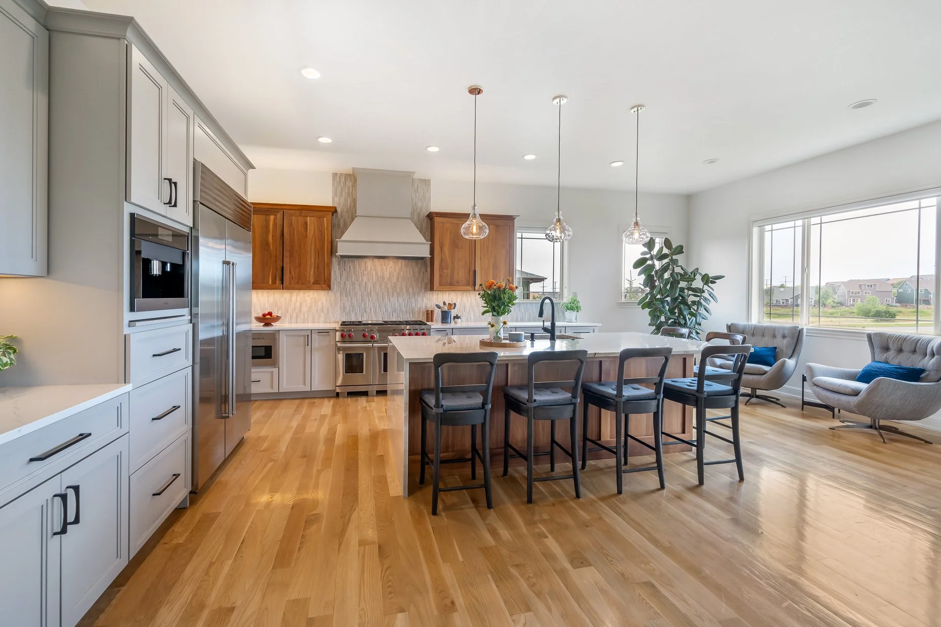 Gorgeous open kitchen design with center island, amazing tile backsplash and walnut cabinetry