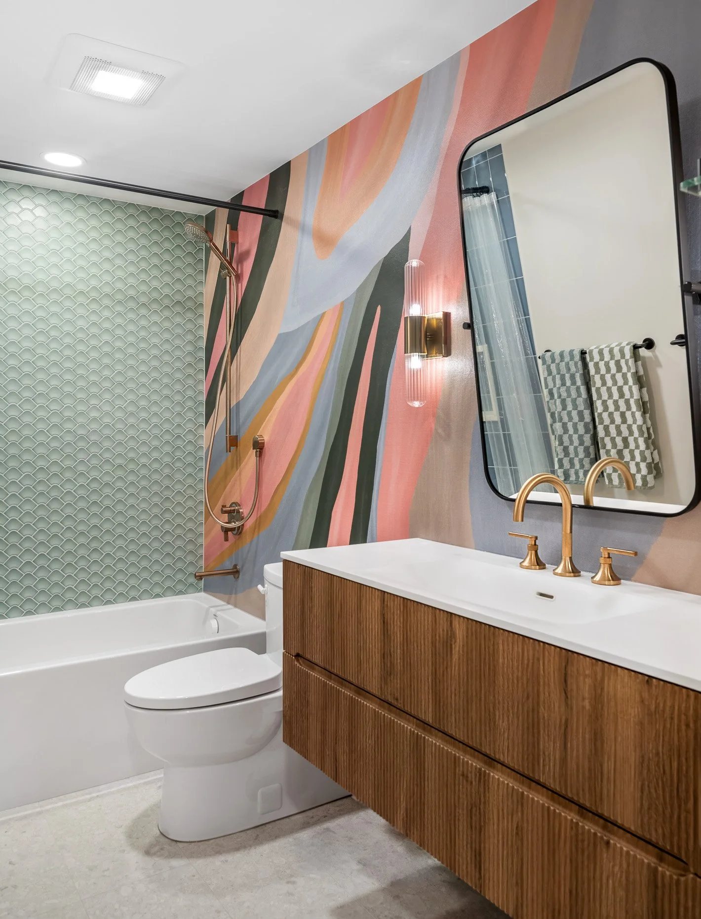 Fun bathroom design with sea colored tiles, walnut cabinetry and large mirror