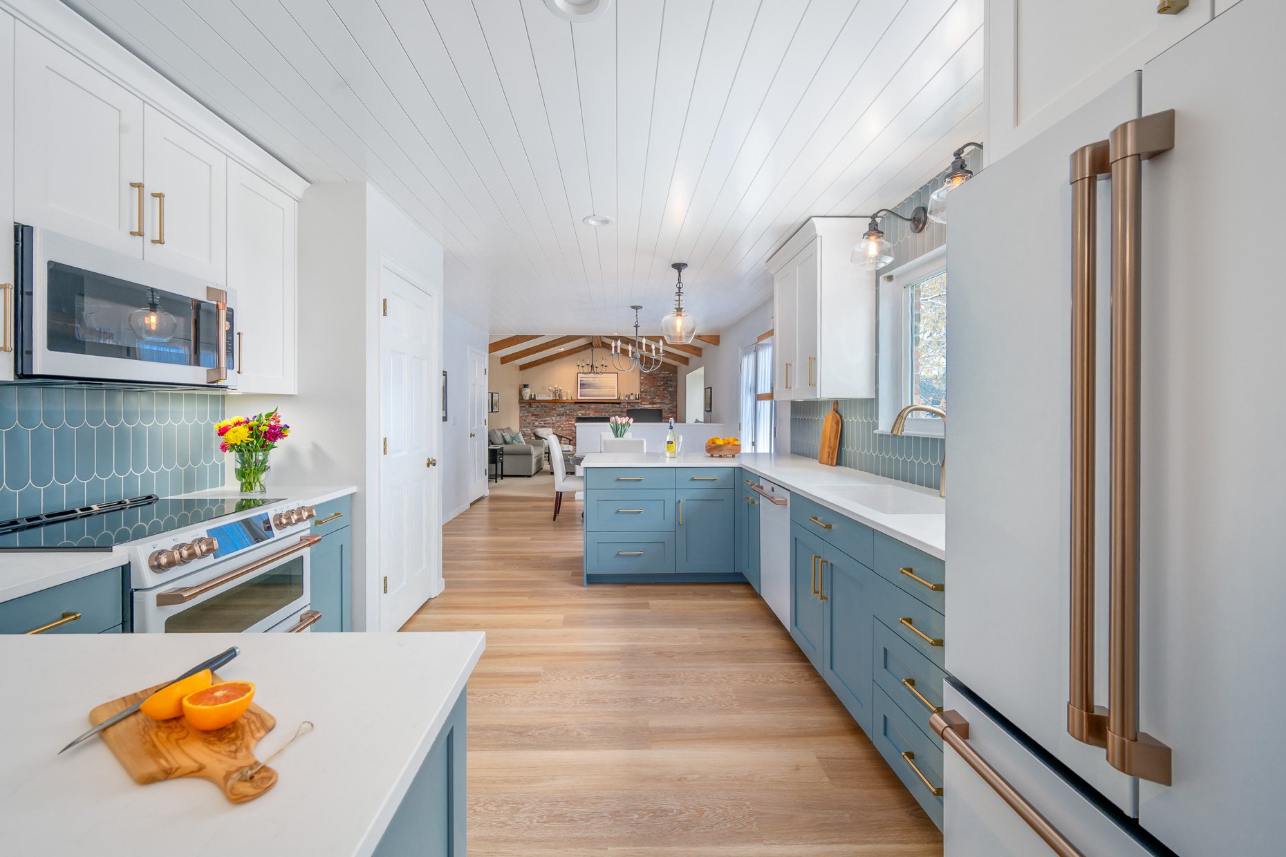 Award winning Cape Cod kitchen design with open cabinetry, wood ceiling, blue accents and designer appliances