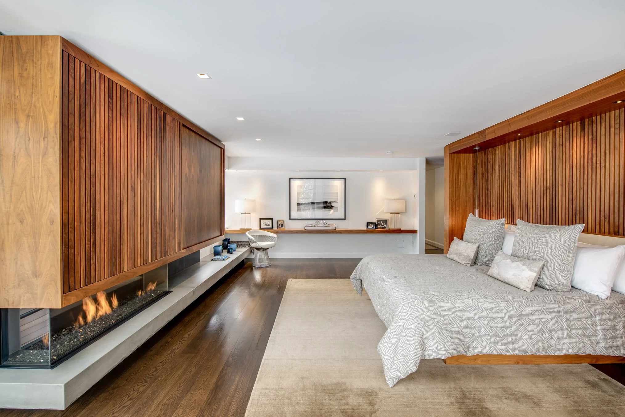 Exceptional primary suite with wood paneling and open fireplace