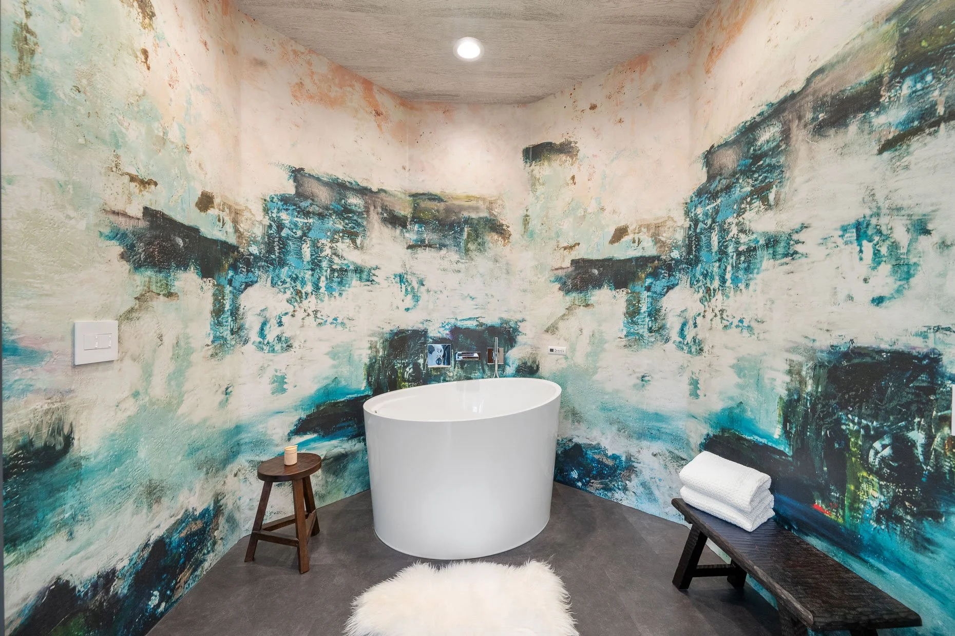Glacier themed bath room with stand alone tub and curved wall