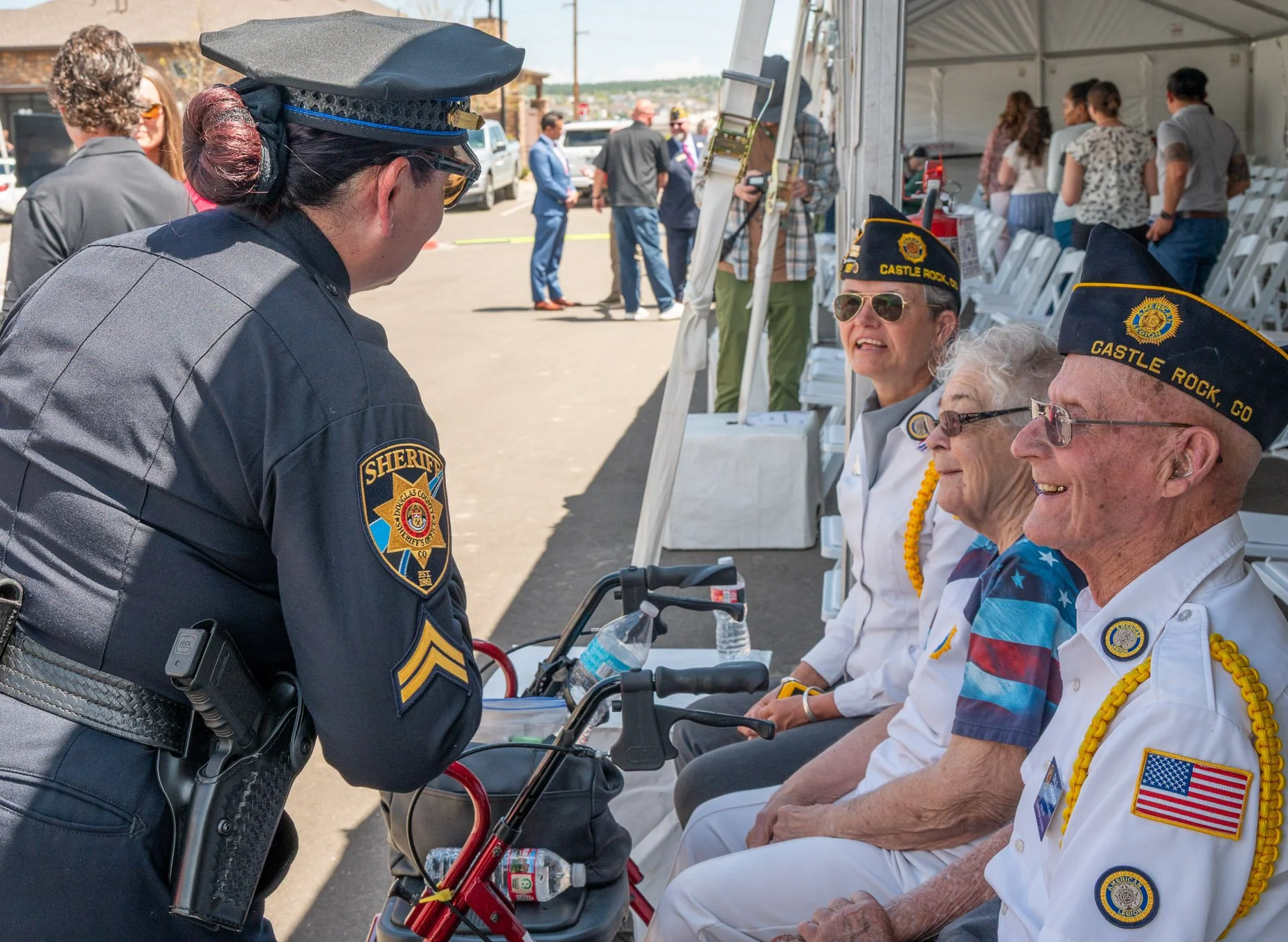 Police woman talking to veterans at a ribbon cutting ceremony