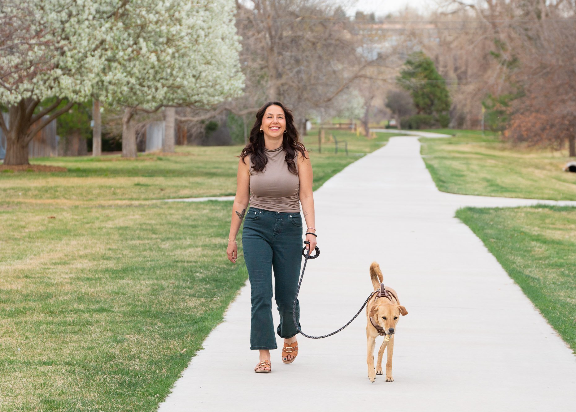 Woman walking dog down long path