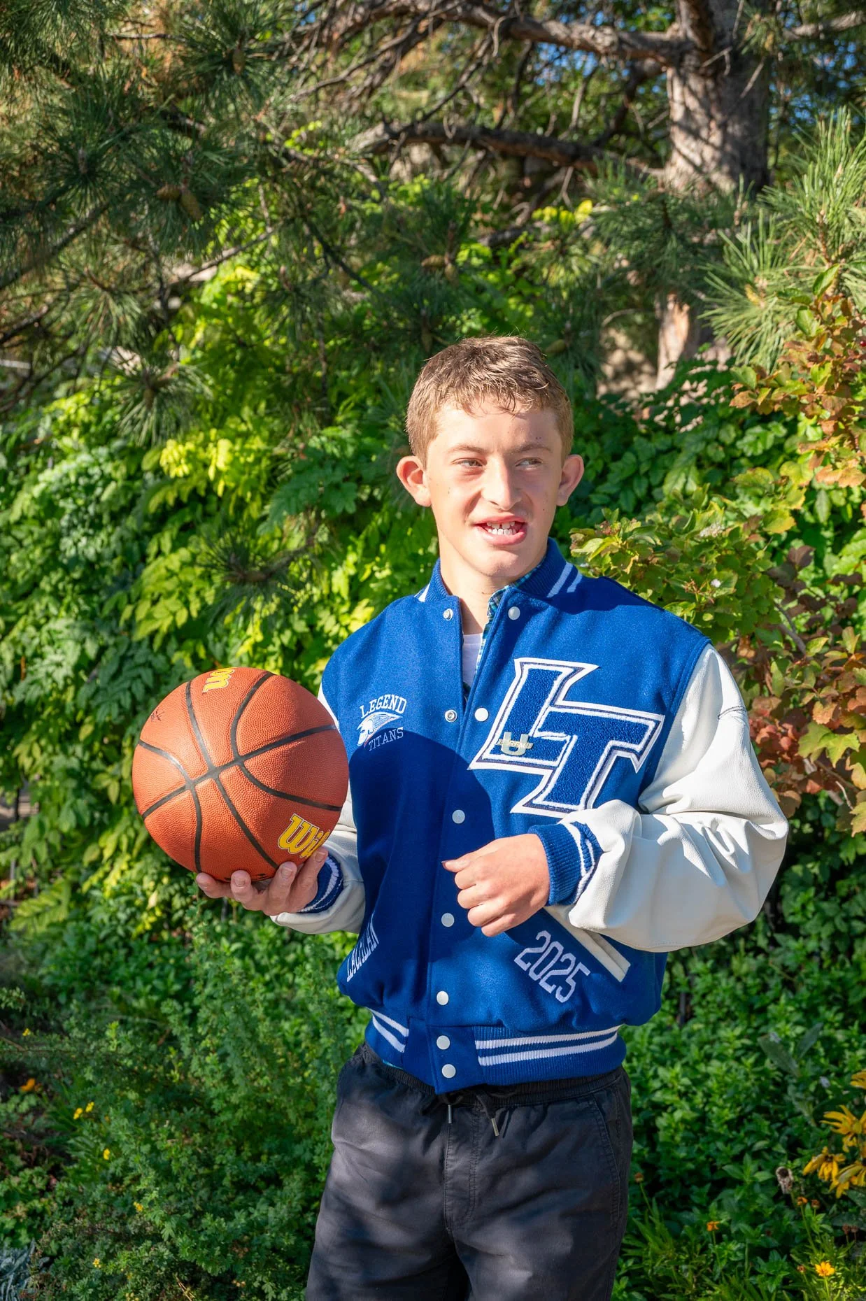 Senior boy with basketball and letter jacket