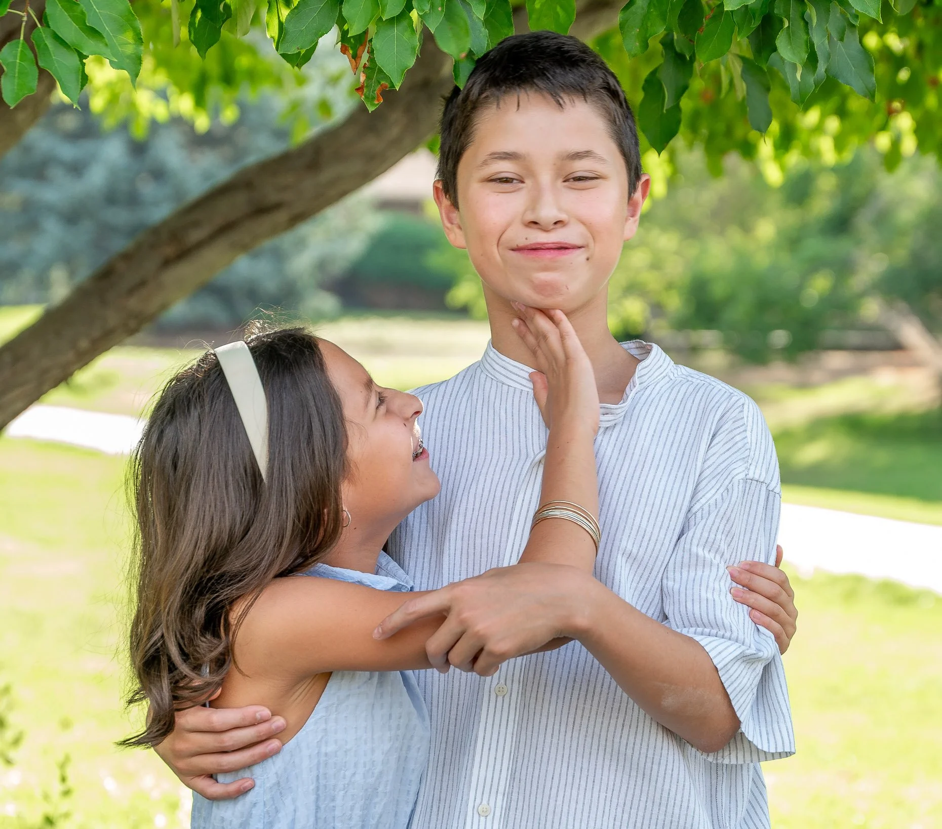 Brother and sister in photo beneath a tree