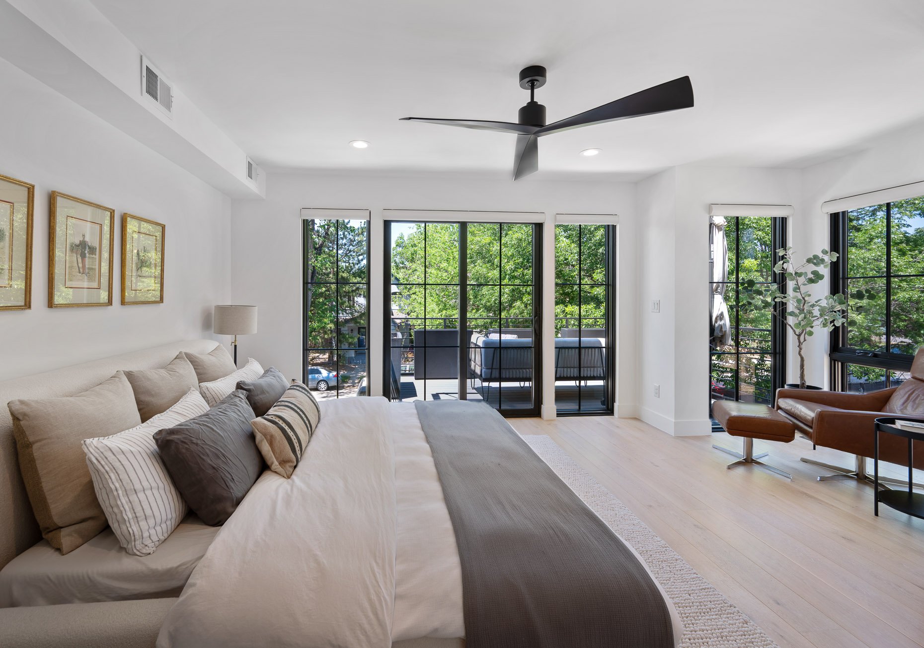 Primary suite with seating area, wall of windows and door to private terrace