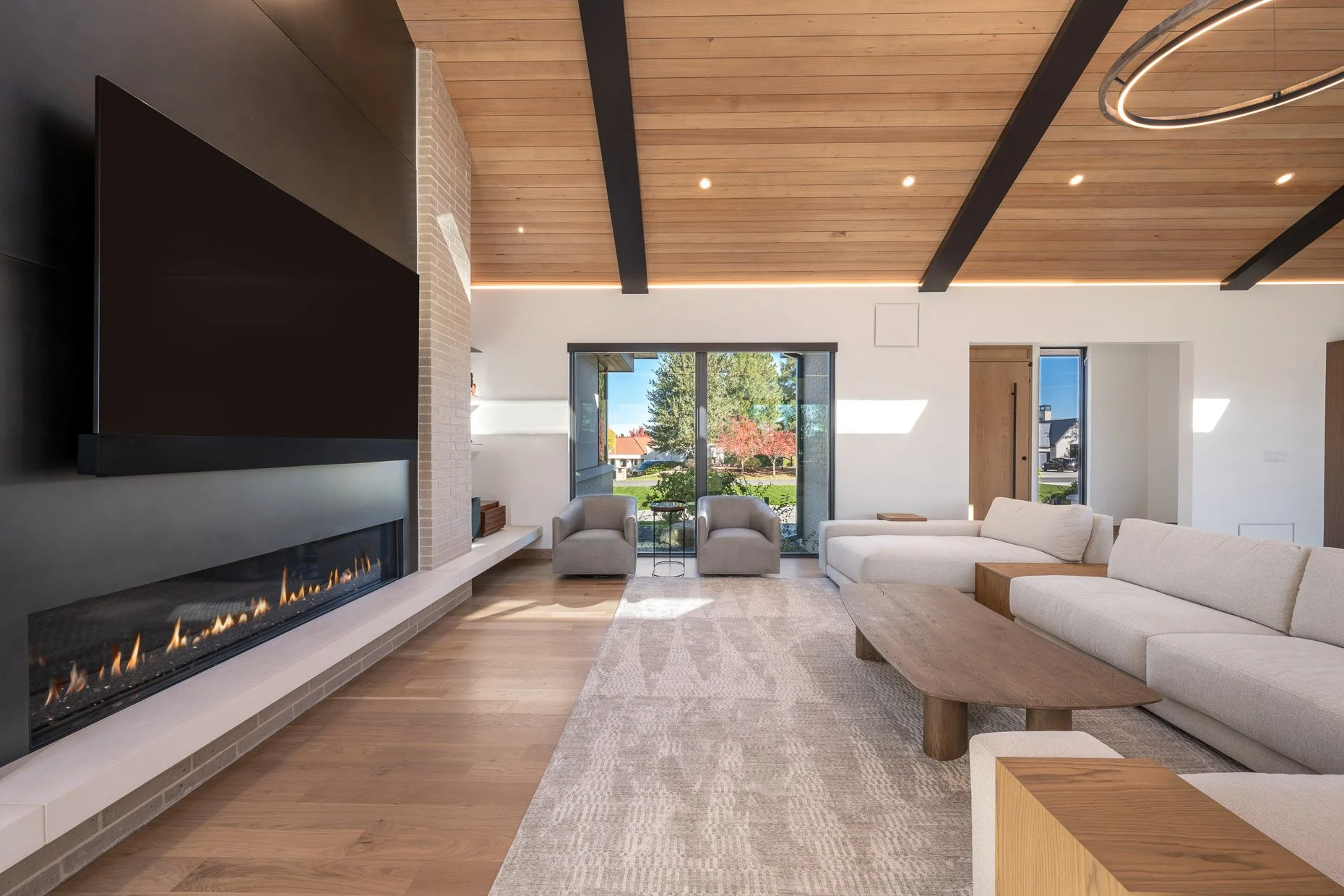 Family room with huge black walled fireplace and wood ceiling 
